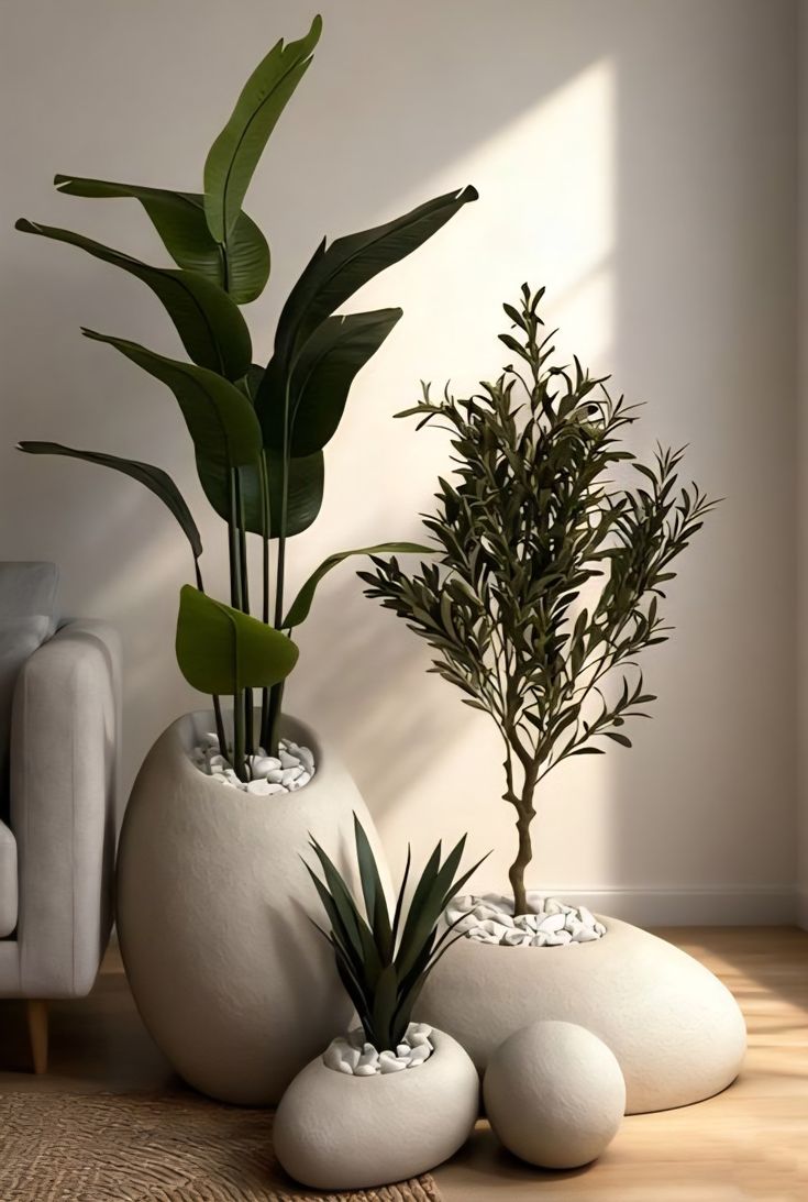 Realistic artificial olive tree branches in a matte black ceramic donut vase on a modern wooden table.